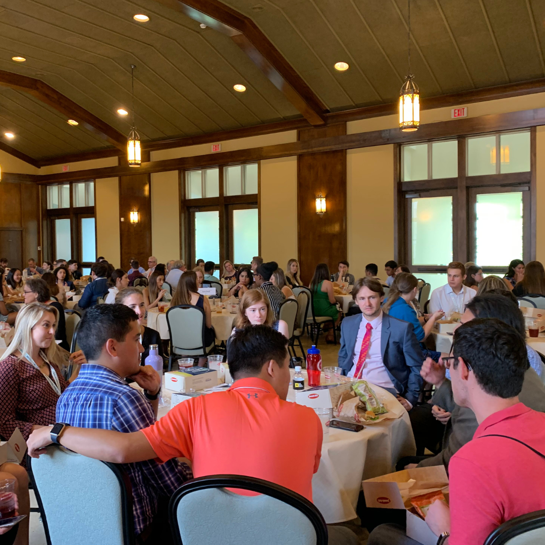 Wide shot from corner angle of groups at luncheon. Circular tables, one table is nearest to view